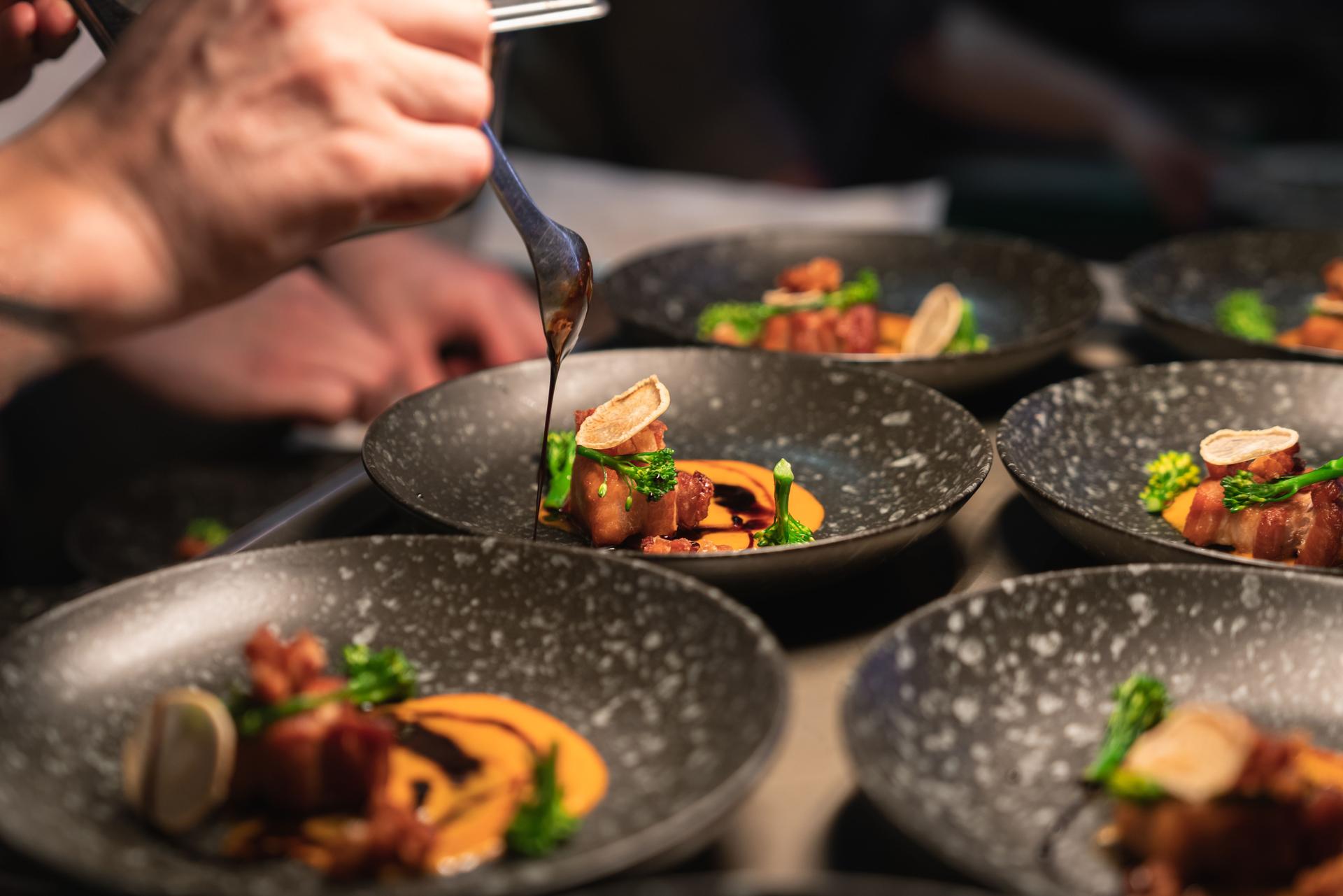 Chefs preparing food in professional kitchen.